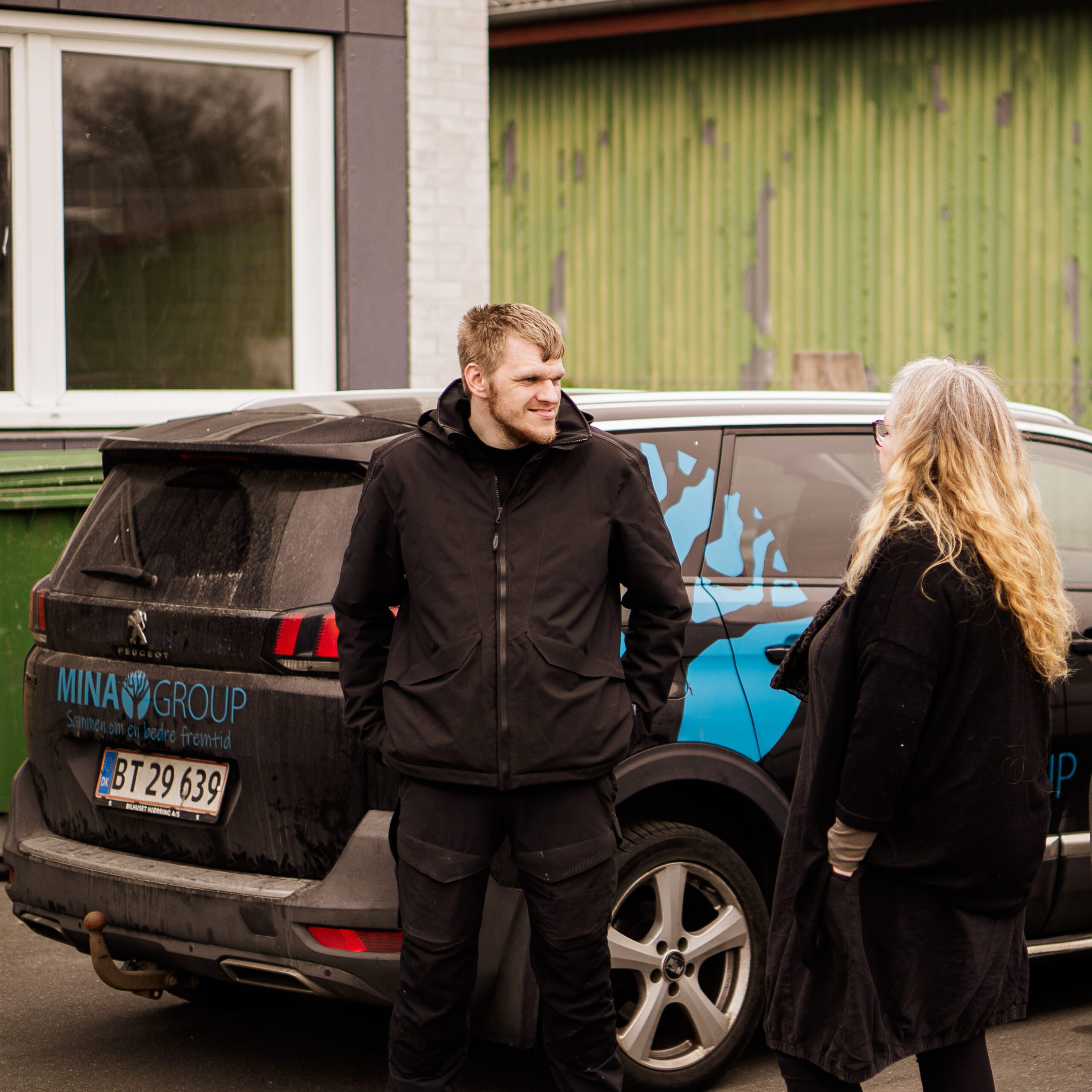 Betina fra Mina Group snakker med en borger foran Mina Group i Korsør.